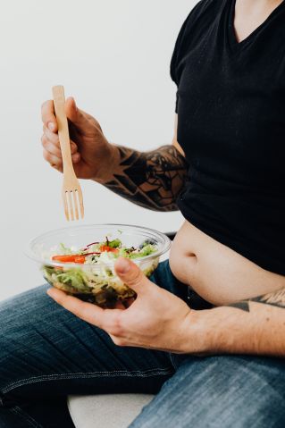 Person in Black Shirt holding a Bowl of Vegetable Salad